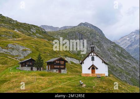 Neogotische Kapelle auf Lüsgen mit zwei hölzernen Chalets, Belalp, Kanton Valais, Schweiz, Europa Stockfoto