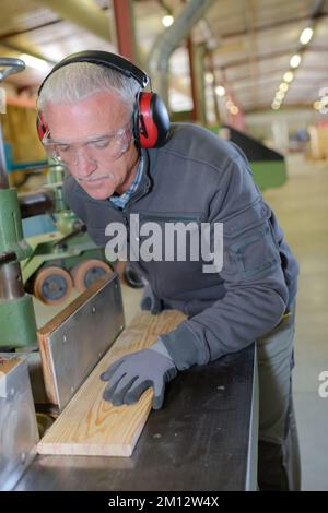 kaukasische Tischlerschrift auf Notizblock in der Werkstatt Stockfoto