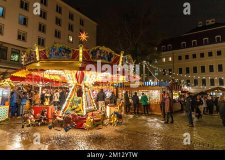 Dresdner Weihnachtsmärkte im Winter 2022, beleuchtet in der Nacht. Im Vordergrund ein Karussell Stockfoto