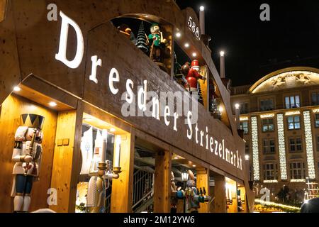 Dresdner Weihnachtsmärkte im Winter 2022, beleuchtet in der Nacht. Im Vordergrund das Zeichen des Dresdner Strietzel Markt 2022. Stockfoto