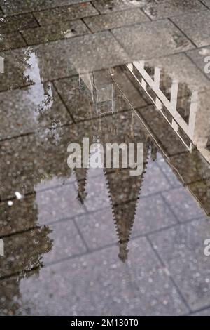 Deutschland, Nordrhein-Westfalen, Köln, Fußgängerzone, nasser Bürgersteig, Der Kölner Dom spiegelt sich in einer Pfütze wider Stockfoto