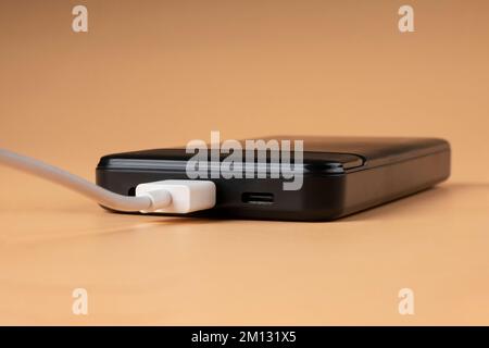 Schwarzes Telefon wird über usb aufgeladen. Stockfoto