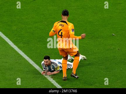 Argentiniens Lionel Messi liegt auf dem Spielfeld, nachdem er während des Viertelfinalspiels der FIFA-Weltmeisterschaft im Lusail-Stadion in Lusail, Katar, von Virgil van Dijk der Niederlande beleidigt wurde. Foto: Freitag, 9. Dezember 2022. Stockfoto