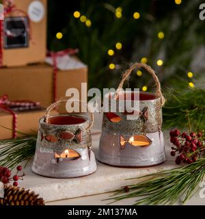 Kerzenhalter aus Keramik mit Geschenkboxen und weihnachtsdekoration Stockfoto