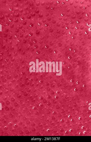 Nahaufnahme von Wassertropfen auf Glasoberfläche abstrakter Hintergrund. Getöntes Bild in trendy magentafarbener Farbe des Jahres 2023. Speicherplatz kopieren. Stockfoto