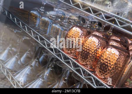 Wunderschöne leere, saubere, umgedrehte Gläser in geraden Reihen in einer Bar Stockfoto