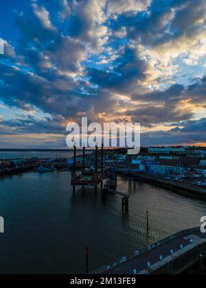 Eine vertikale Aufnahme der Dartford Bridge in England mit Blick auf den farbenfrohen Sonnenuntergang und die städtischen Gebäude Stockfoto