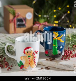 weihnachtlich dekorierte Kaffeetassen aus Keramik mit Geschenkboxen und weihnachtsbaum Stockfoto