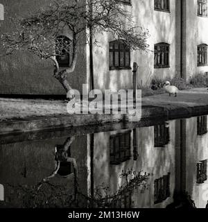 Schwarzweißfoto von British Waterways Canalside mit einem Sepia-farbigen Infrarotbild mit Lichtformen, die auf der Wasseroberfläche gespiegelt sind Stockfoto