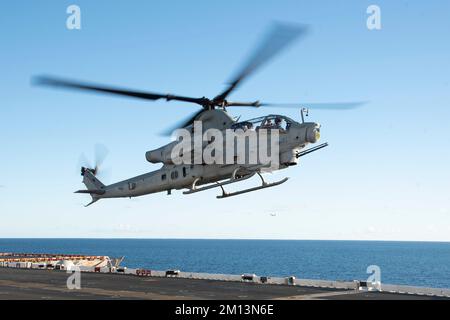 221207-N-XN177-2102 PAZIFIK (7. Dez. 2022) – ein AH-1Z Viper-Hubschrauber, der dem Marine Light Attack Helicopter Squadron (HMLA) 369 zugeteilt ist, landet an Bord des Amphibienflugzeugträgers USS Tripoli (LHA 7) am 7. Dez. 2022. Tripoli führt gerade Routineeinsätze in der US-3.-Flotte durch. (USA Marinebild von Mass Communication Specialist 1. Class Peter Burghart) Stockfoto