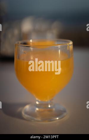 Ein Glas Poncha, ein traditionelles Getränk der Insel Madeira mit Zitrusfrüchten, Honig und regionalem Zuckerrohr-Brandy. Nahaufnahme eines trinkfertigen Glases Stockfoto