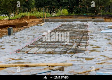 Baustelle eine Installation von Bewehrungsstahlstäben auf Betonfundamenten während des Bauprozesses Stockfoto