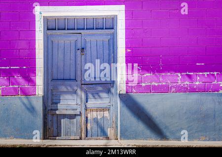 Rustikale alte Holztür mit strukturierter wandfassade aus lehmziegeln in Cusco, Peru Stockfoto