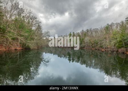 Das glasige Wasser am Byrd Creek Lake im Cumberland State Park, Tennessee, bietet an einem kalten, regnerischen Tag eine wunderschöne Kulisse für Naturszenen. Stockfoto