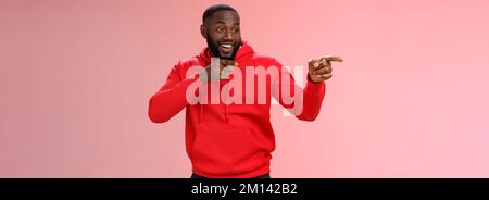 Hey, Mann, was ist. Portrait frech selbstbewusst ausgehende afroamerikanische bärtige Mann in Club sehen Freunde machen hallo Geste zeigen linken Finger Stockfoto