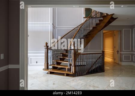 Schicke Wendeltreppe aus Holz mit Stahlbalustern in einem großen Haus. Dieses Haus wurde seitdem abgerissen. Stockfoto