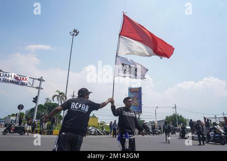 Malang, Ost-Java, Indonesien. 8.. Dezember 2022. Ein Demonstrante trägt während des Protests eine indonesische Nationalflagge in Rot und Weiß. Aremania, die Anhänger des FC Arema, hielt eine Kundgebung ab und blockierte an einigen Stellen in Malang die Straßen, um gegen den legalen Prozess der Tragödie der Fußball-Stampede zu protestieren, bei der am 1. Oktober 2022 135 Menschen durch das Tränengas der Polizei im Kanjuruhan-Stadion ums Leben kamen. (Kreditbild: © Dicky Bisinglasi/SOPA Bilder über ZUMA Press Wire) Stockfoto