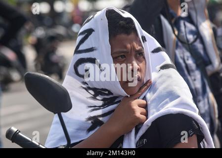 Malang, Ost-Java, Indonesien. 8.. November 2022. Ein junger Demonstrante wird während des Protests mit einem Protestbanner bedeckt gesehen. Aremania, die Anhänger des FC Arema, hielt eine Kundgebung ab und blockierte an einigen Stellen in Malang die Straßen, um gegen den legalen Prozess der Tragödie der Fußball-Stampede zu protestieren, bei der am 1. Oktober 2022 135 Menschen durch das Tränengas der Polizei im Kanjuruhan-Stadion ums Leben kamen. (Kreditbild: © Dicky Bisinglasi/SOPA Bilder über ZUMA Press Wire) Stockfoto