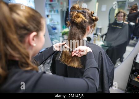 08. Dezember 2022, Sachsen-Anhalt, Wettin-Löbejün: Ein Friseur schneidet einem Kunden in einem Salon die Haare. Die 21-Jährige wird in naher Zukunft den Salon ihrer Großmutter übernehmen. Foto: Jan Woitas/dpa Stockfoto