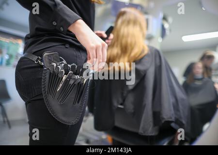 08. Dezember 2022, Sachsen-Anhalt, Wettin-Löbejün: Ein Friseur schneidet einem Kunden in einem Salon die Haare. Die 21-Jährige wird in naher Zukunft den Salon ihrer Großmutter übernehmen. Foto: Jan Woitas/dpa Stockfoto