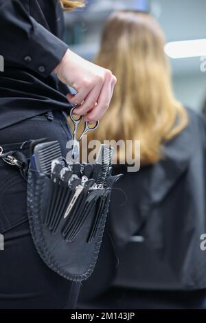 08. Dezember 2022, Sachsen-Anhalt, Wettin-Löbejün: Ein Friseur schneidet einem Kunden in einem Salon die Haare. Die 21-Jährige wird in naher Zukunft den Salon ihrer Großmutter übernehmen. Foto: Jan Woitas/dpa Stockfoto