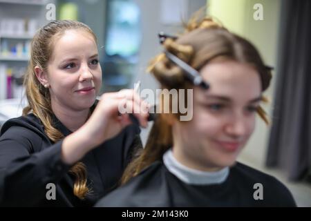 08. Dezember 2022, Sachsen-Anhalt, Wettin-Löbejün: Cheffriseur Jasmin Härzer schneidet einem Kunden die Haare. Die 21-Jährige wird in naher Zukunft den Salon ihrer Großmutter übernehmen. Foto: Jan Woitas/dpa Stockfoto