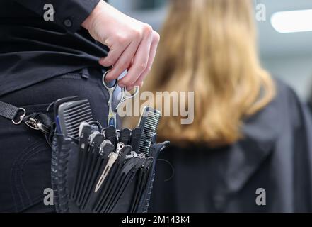 08. Dezember 2022, Sachsen-Anhalt, Wettin-Löbejün: Ein Friseur schneidet einem Kunden in einem Salon die Haare. Die 21-Jährige wird in naher Zukunft den Salon ihrer Großmutter übernehmen. Foto: Jan Woitas/dpa Stockfoto