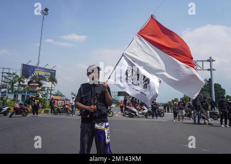 Malang, Ost-Java, Indonesien. 8.. Dezember 2022. Ein Demonstrante trägt während des Protests eine indonesische Nationalflagge in Rot und Weiß. Aremania, die Anhänger des FC Arema, hielt eine Kundgebung ab und blockierte an einigen Stellen in Malang die Straßen, um gegen den legalen Prozess der Tragödie der Fußball-Stampede zu protestieren, bei der am 1. Oktober 2022 135 Menschen durch das Tränengas der Polizei im Kanjuruhan-Stadion ums Leben kamen. (Kreditbild: © Dicky Bisinglasi/SOPA Bilder über ZUMA Press Wire) Stockfoto