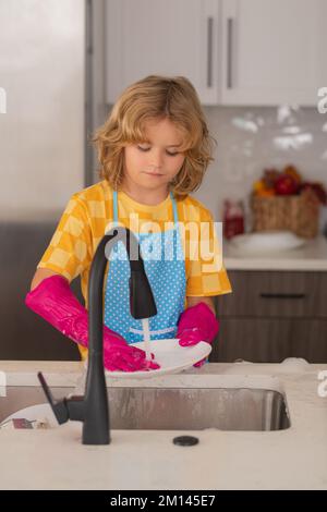 Reinigung zu Hause. Kind wäscht Geschirr im Küchenbereich. Kinderhilfe bei der Hausarbeit. Konzept für die allgemeine Ordnung und Sauberkeit und Hausreinigung. Staubwedel für Kinder Stockfoto