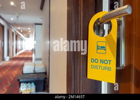 Das Schild „Bitte nicht stören“ hängt an der Türklinke des offenen Hotelzimmers Stockfoto