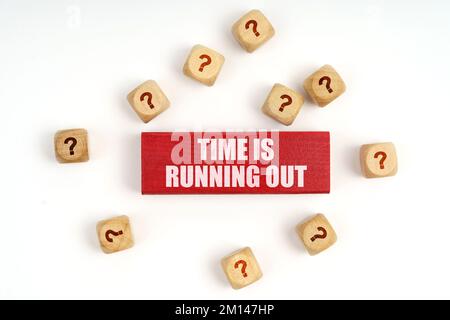 Fragekonzept. Auf dem Tisch liegen Würfel mit Fragen und eine rote Tafel mit der Inschrift – die Zeit läuft ab Stockfoto