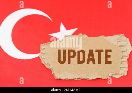 Geschäfts- und Finanzkonzept. Vor dem Hintergrund der türkischen Flagge liegt Pappe mit der Inschrift - Update Stockfoto