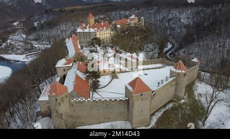 Eine Drohnenaufnahme von Schloss Veveri mit Waldbäumen auf verschneiten Straßen in Brünn, Tschechien im Winter Stockfoto