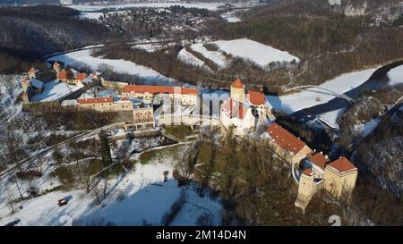 Eine Drohnenaufnahme von Schloss Veveri mit Waldbäumen auf verschneiten Straßen in Brünn, Tschechien im Winter Stockfoto