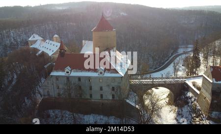 Eine Drohne schoss über Schloss Veveri mit Waldbäumen in Brünn, Tschechien und verschneitem Boden Stockfoto