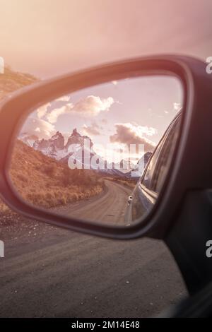 Eine vertikale Aufnahme einer wunderschönen Landschaft mit schneebedeckten Bergen, die sich im Spiegel des Autos in Chile widerspiegelt Stockfoto