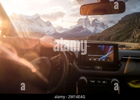 Eine Autofahrt mit der wunderschönen Landschaft eines Sees und schneebedeckten Bergen im Hintergrund Stockfoto