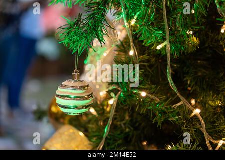 Nahaufnahme der Weihnachtsschmuck, die am Weihnachtsbaum hängen. Stockfoto