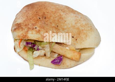 Flat Shami Syrian Bread gefüllt mit pommes Frites und grünem Salat, traditionelle ägyptische frittierte Kartoffeln Finger Sandwich umgeben von kühlen und knusprigen umgeben Stockfoto