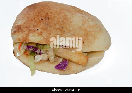 Flat Shami Syrian Bread gefüllt mit pommes Frites und grünem Salat, traditionelle ägyptische frittierte Kartoffeln Finger Sandwich umgeben von kühlen und knusprigen umgeben Stockfoto