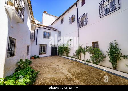 Häuser mit weißen Fassaden und metallgegrillten Fenstern im malerischen andalusischen Dorf Ronda, Malaga. Stockfoto