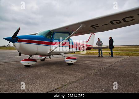 CAEN, FRANKREICH - JUNI ETWA 2016. Privates Cesna-Flugzeug auf der Rollbahn eines kleinen Regionalflughafens mit Pilot und Kunde, die das Flugzeug vor dem Flug inspizieren Stockfoto