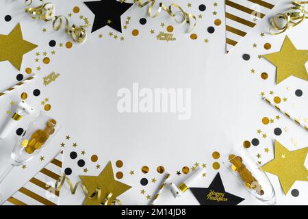 Silvesterfeier. Goldene und schwarze Dekorationen, Konfetti, Champagnerglas, Hornblasgeräte. Frohes neues Jahr, Flachbett mit Kopierbereich. Stockfoto