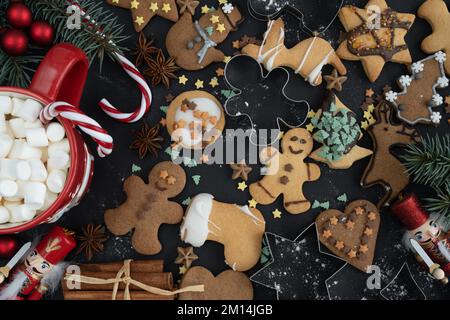Dekorierte Lebkuchen-Weihnachtskekse, Keksformen, heißer Schokoladen-Kakao mit Marshmallows. Weihnachtszeit Winter flach liegend Komposition. Stockfoto