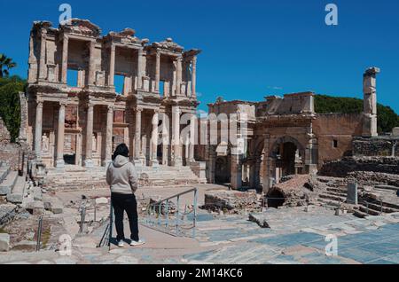 Ein zwangloser asiatischer Mann, der die Celsus-Bibliothek in der antiken Stadt Ephesus in Izmir, Türkei, betrachtet Stockfoto