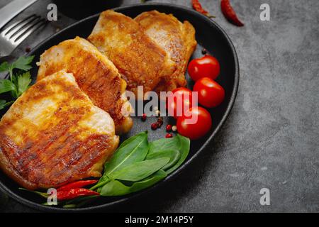 Gegrillte Schweinesteaks in einer Pfanne mit Gewürzen mit Platz zum Kopieren Stockfoto