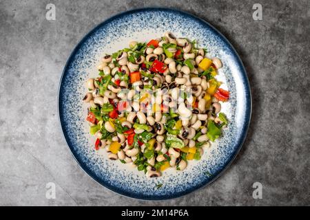 Getrockneter Kuhbohensalat auf dunklem Hintergrund. Türkische Küche mit Vorspeisen. Draufsicht. Schließen Stockfoto