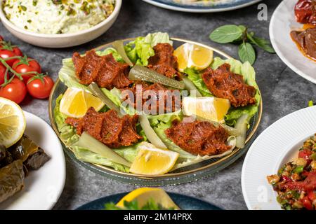 Traditioneller türkischer und griechischer Vorspeisentisch. Mediterranes Vorspeisenkonzept. Rohe Fleischbällchen, gerösteter Auberginen-Salat, gefüllte Oliven, gefüllt Stockfoto