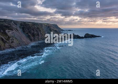 Wunderschöne Luftdrohnenlandschaft Sonnenuntergang Bild von Welcombe Mouth Beach in Devon England Stockfoto