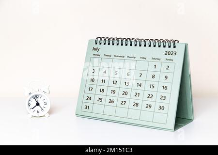 Kalender vom 2023. Juli und kleine Uhr auf weißem Hintergrund isoliert Stockfoto